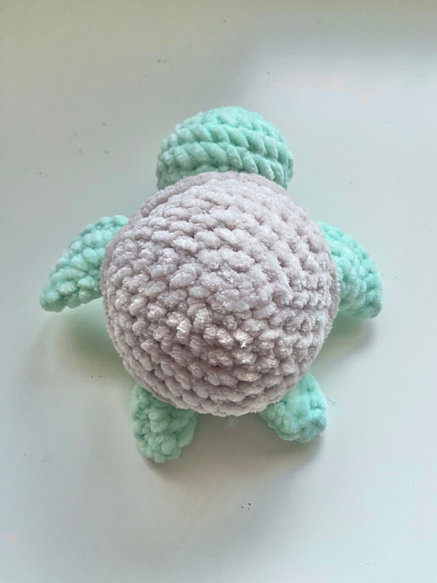 The top of one completed turtle plushie sitting on a white background