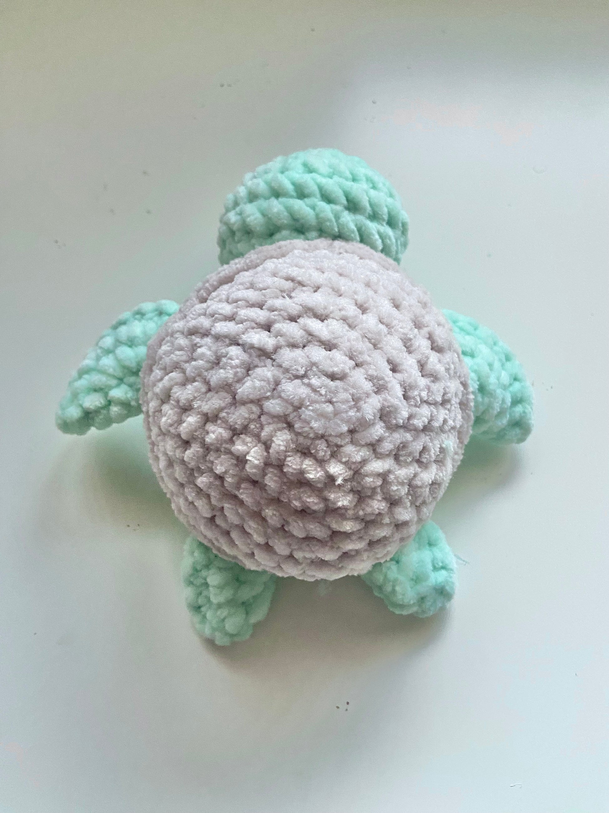 The top of one completed turtle plushie sitting on a white background 